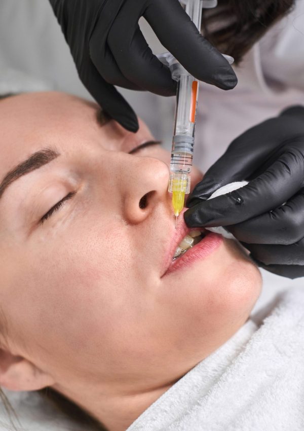Professional,Administers,Dermal,Filler,Injection,To,Relaxed,Young,Woman,,Highlighting